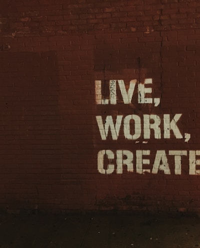 red brick wall with live, work, create. quote